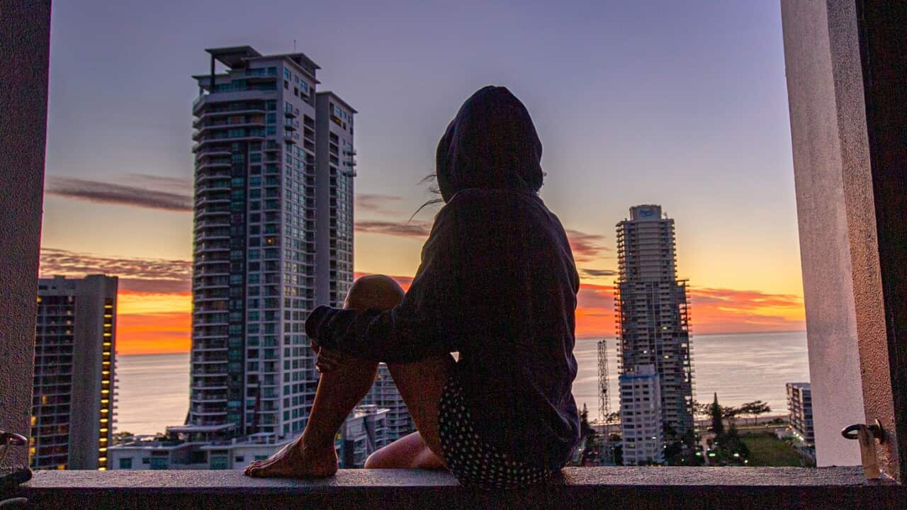 Woman sitting at her balcony looking out at sunrise view