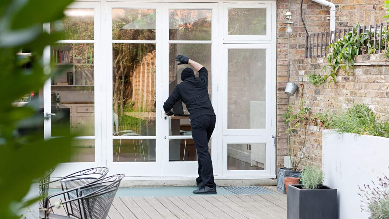 Burglar standing at patio door