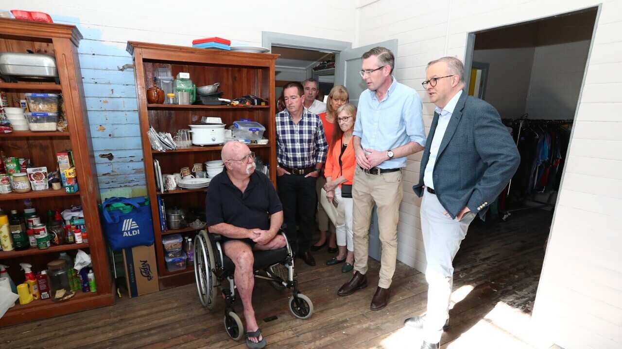 (L-R) Prime Minister Anthony Albanese and NSW Premier Dominic Perrottet meet resident Brian Burgin in Lismore (AAP).