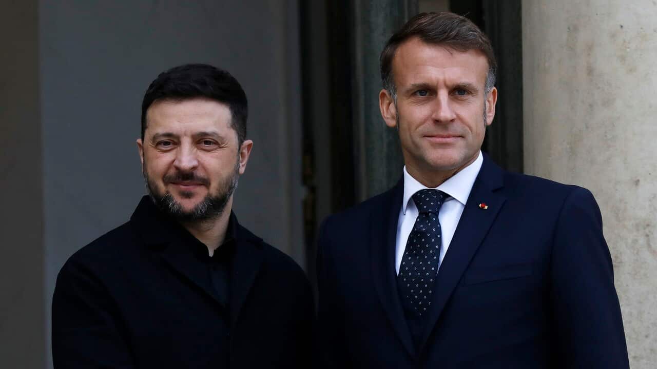 A man in a suit stands with another man