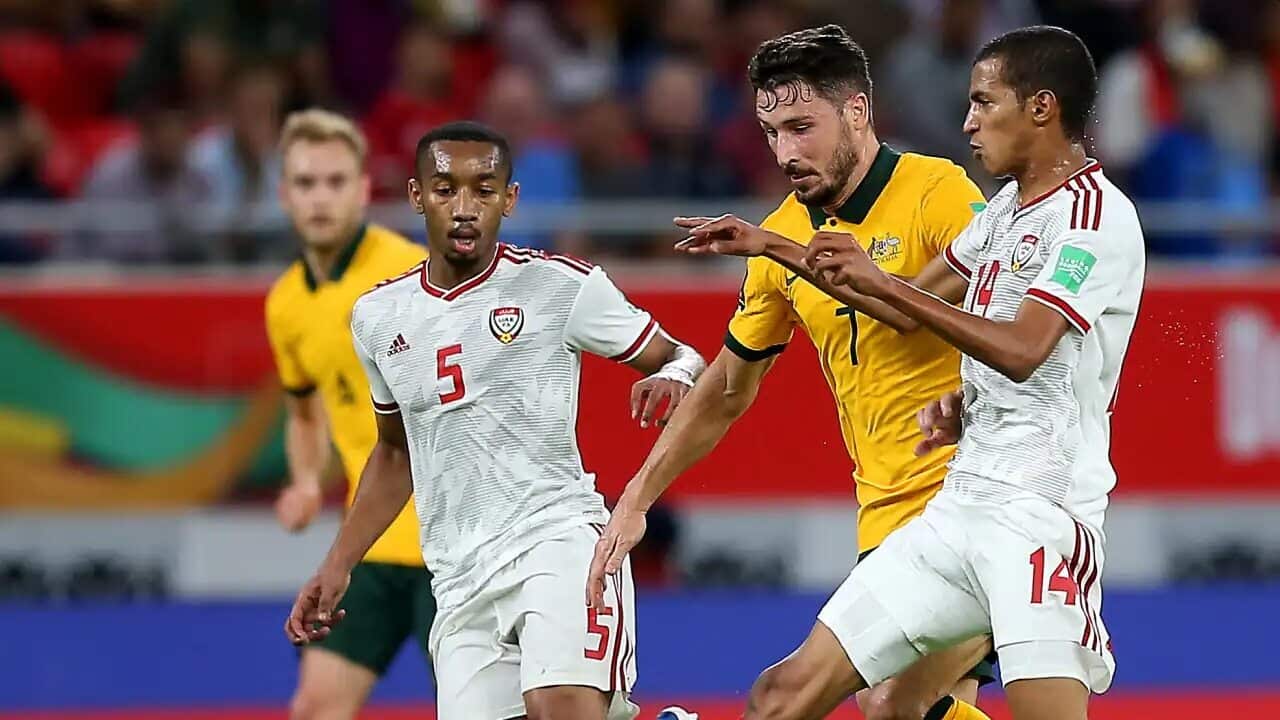 Mathew Leckie of Australia is challenged by Hasan Ali and Abdulla Hamad of United Arab Emirates during the 2022 FIFA World Cup Playoff match between United Arab Emirates and Australia at Ahmad Bin Ali Stadium on 7 June, 2022 in Doha, Qatar.