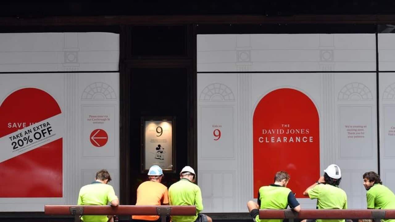 Construction workers sit outside the David Jones store in Sydney