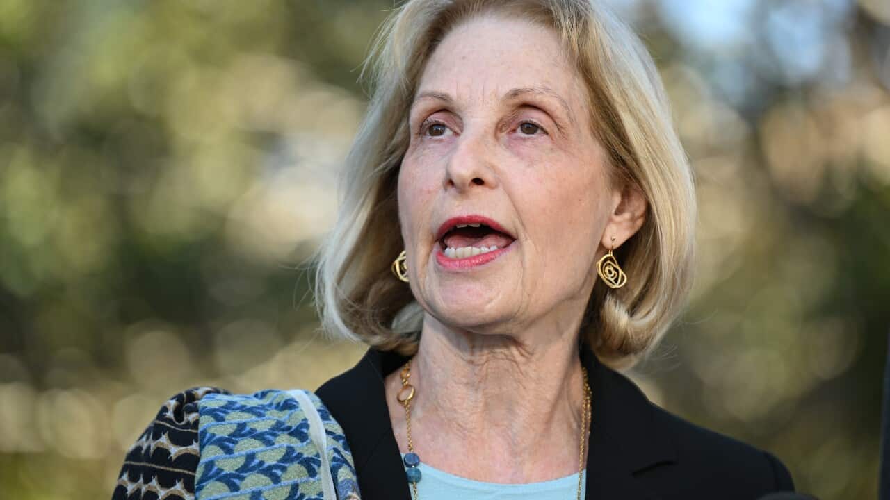 A blonde woman speak to the media