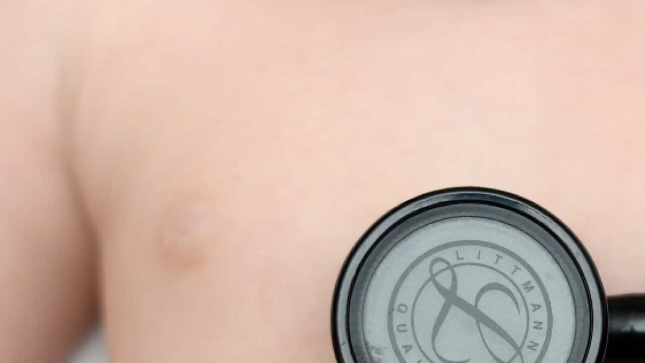A 5 months old baby has her heart checked by a Doctor with a stethoscope