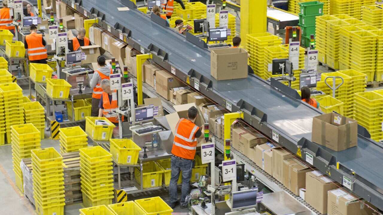 Employees work at a distribution centre of Amazon