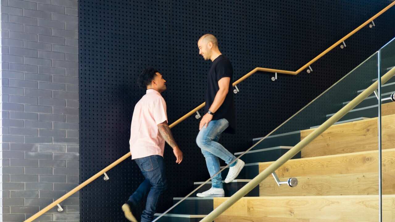 Two men smiling as they pass each other