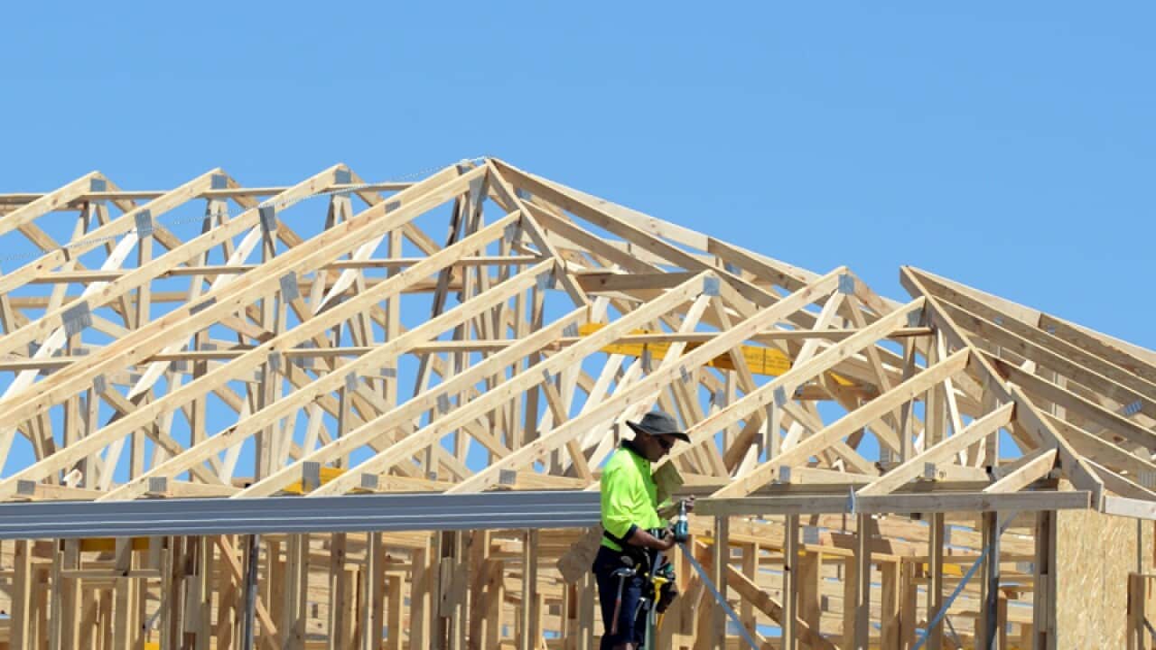A carpenter is seen working on a home