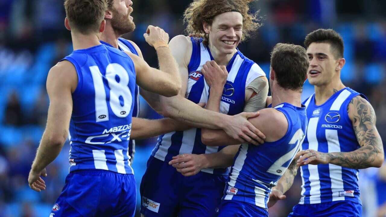 Ben Brown of the Kangaroos (centre) is congratulated on a goal