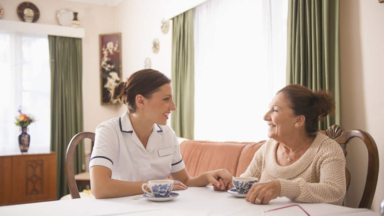 Hispanic nurse talking to senior woman