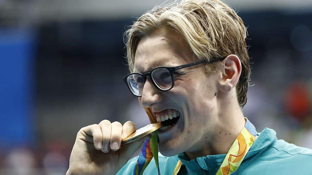 Australia's Mack Horton bites his gold medal on the podium of the Men's 400m Freestyle Final during the swimming event at the Rio 2016 Olympic Games.