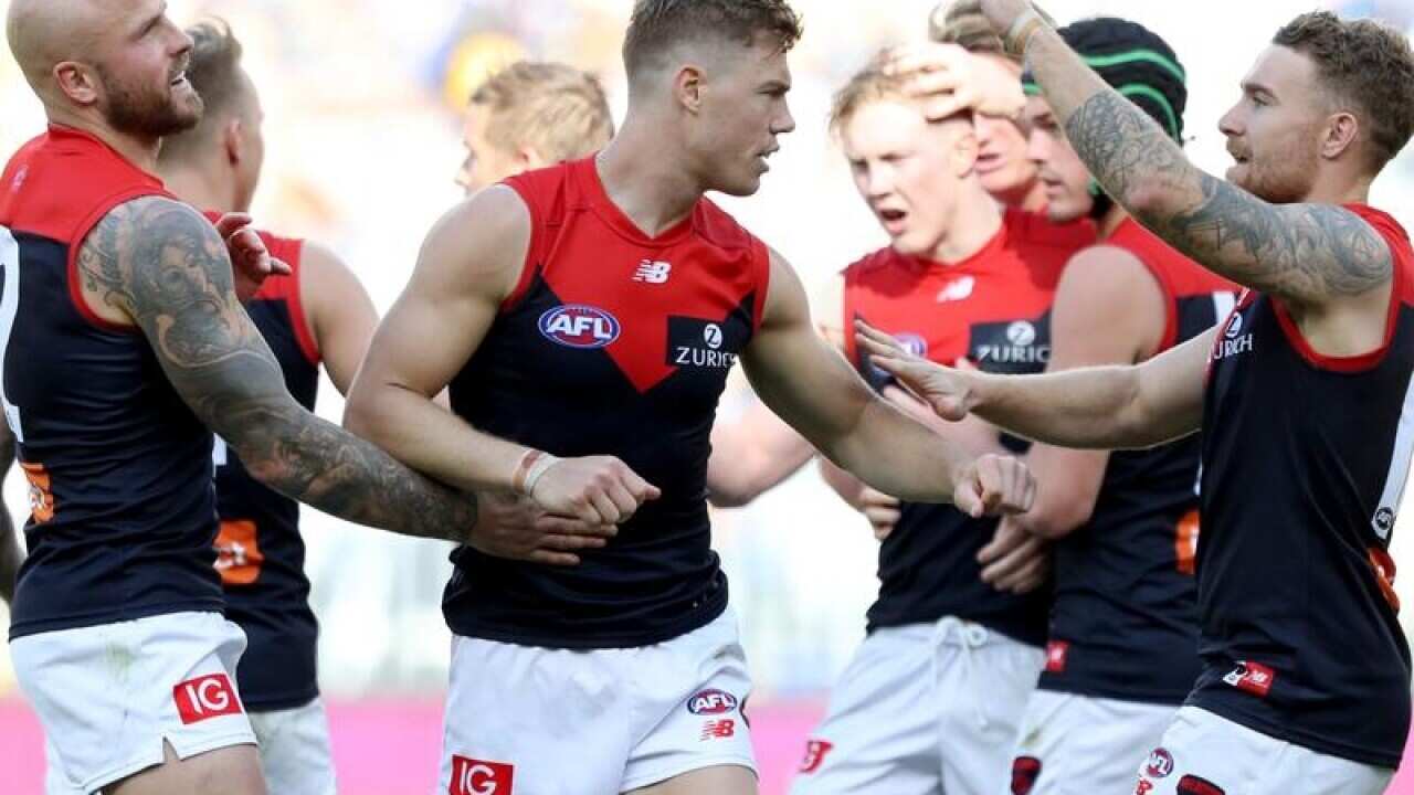 Jake Melksham of the Demons (C) celebrates after kicking a goal