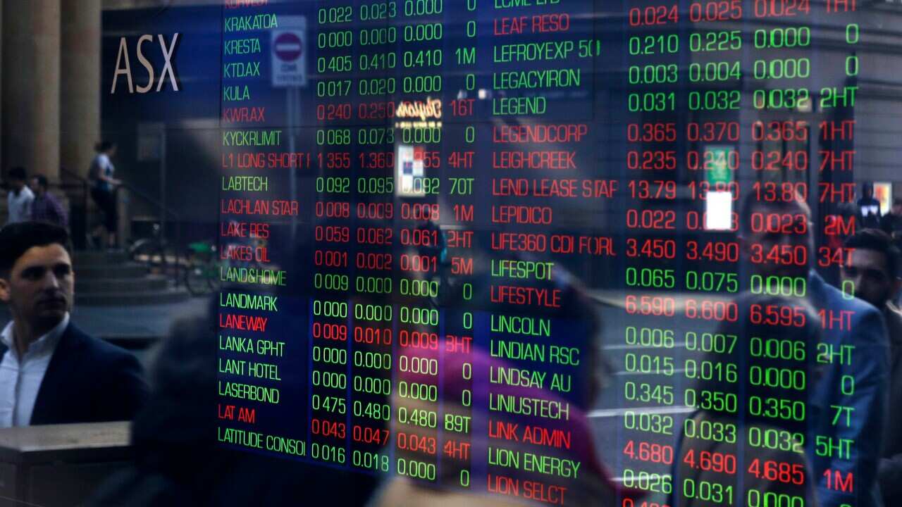 People are reflected in a window as they walk past the Australian Stock Exchange in Sydney