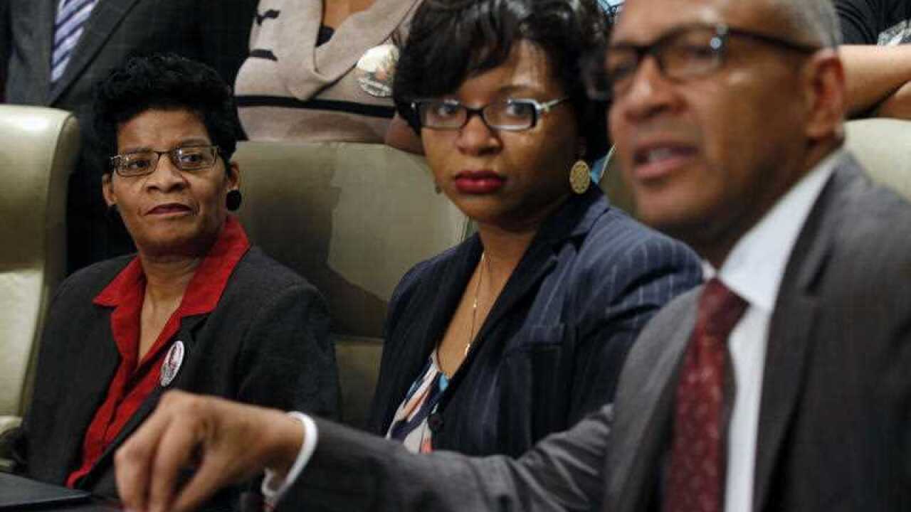 Geneva Reed-Veal, left, and Sharon Cooper, center, the mother and sister of Sandra Bland, listen to attorney Larry Rogers Jr., right, explain concerns about the Texas grand jury's role in the death of Naperville resident Sandra Bland.