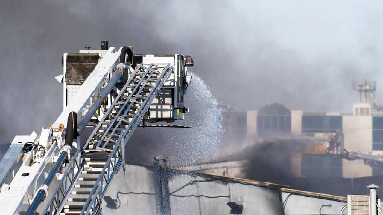 Firefighters hose down a factory fire from a ladder in Melbourne.