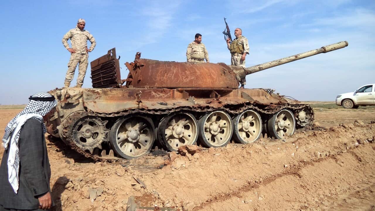 File photo: Iraqi soldiers stand on a damaged tank during fighting against IS militants near Tikrit, northern Iraq, 24 February 2015.  (EPA/ALI MOHAMMED)