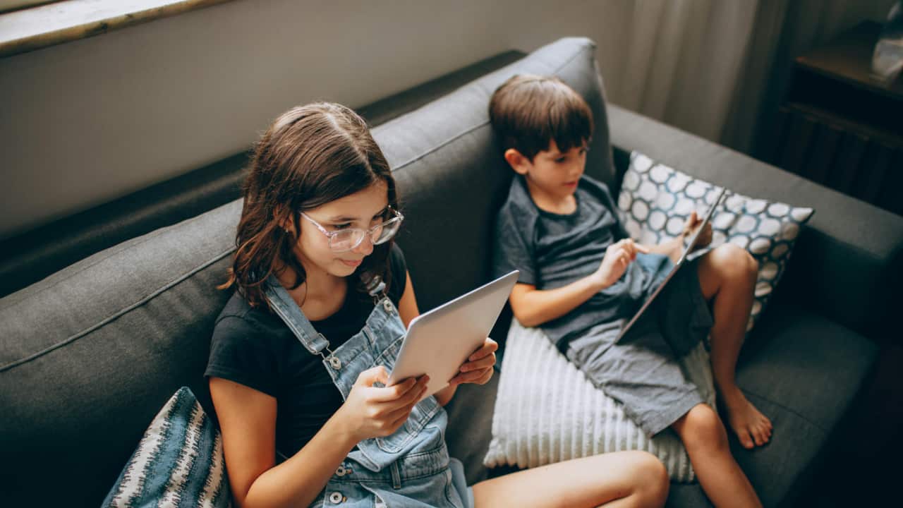 children using gadget on couch