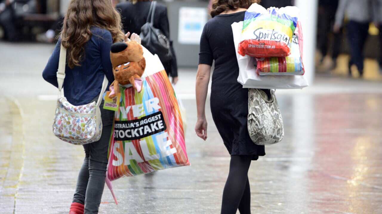 Consumers walk with their purchases.