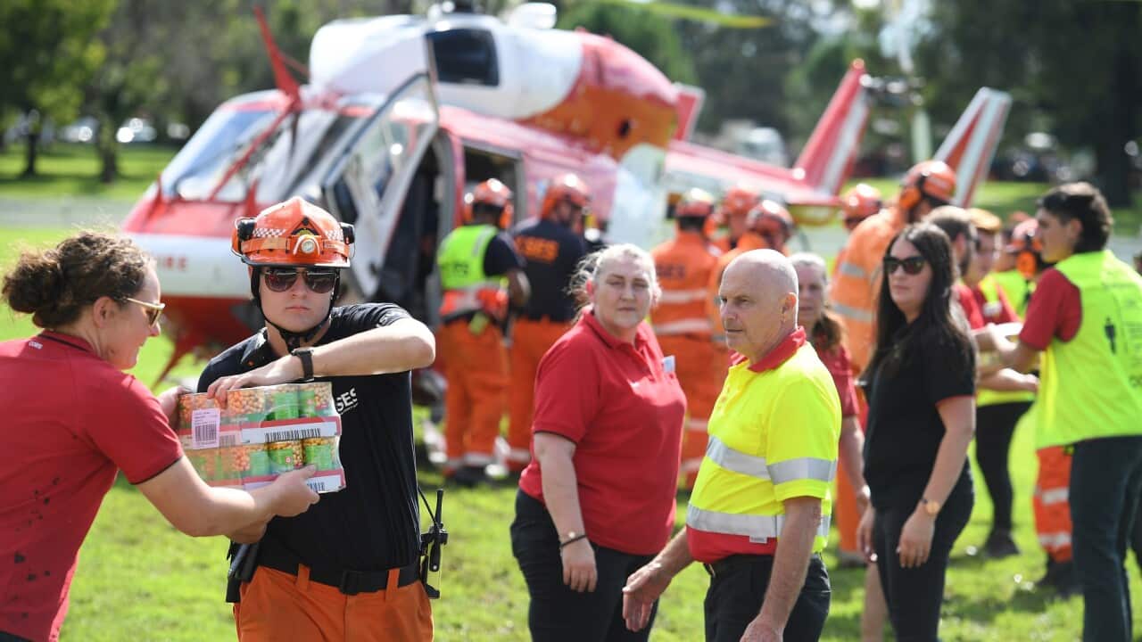 Volunteers load food and essential items onto a rescue helicopter during the March floods in NSW