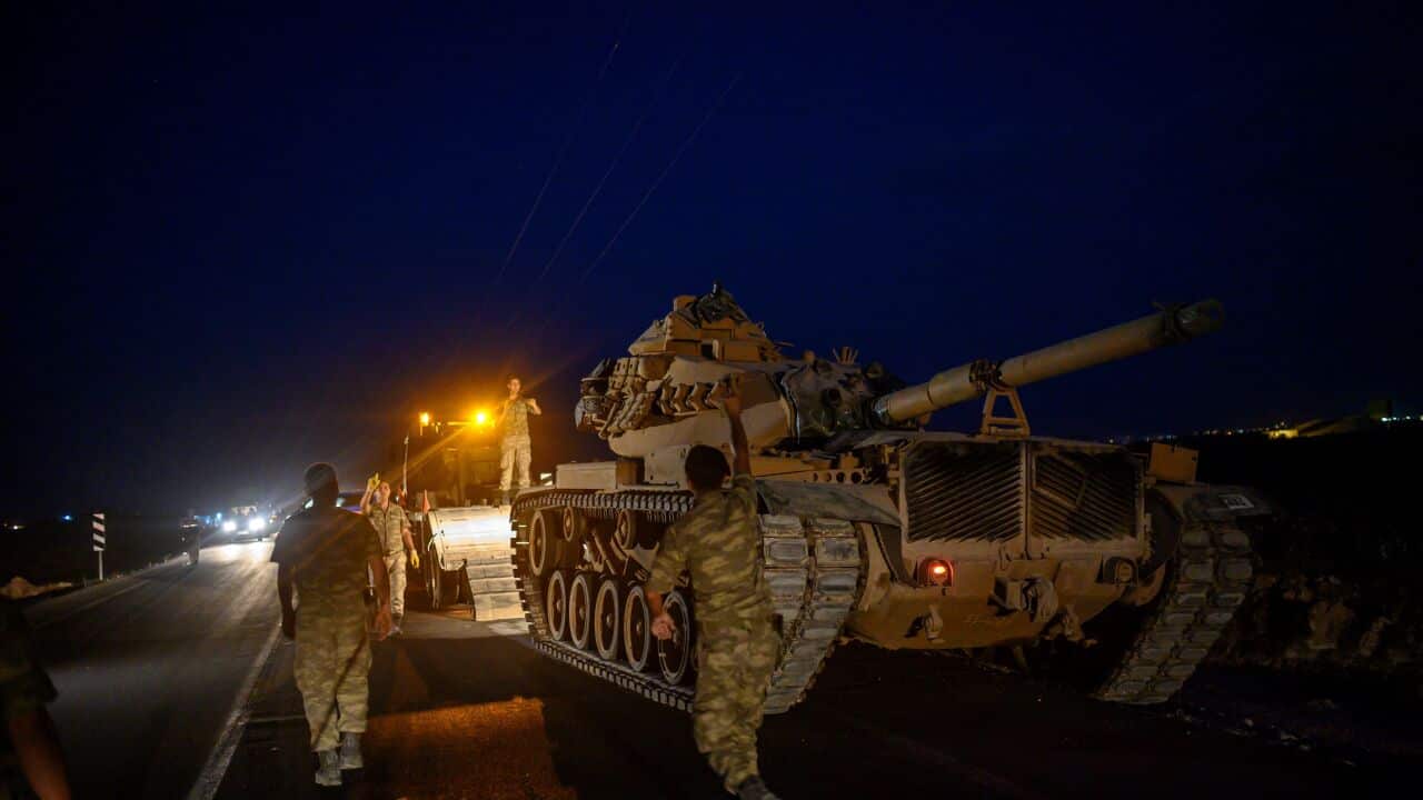 A Turkish army's tank drives down from a truck as Turkish armed forces drive towards the border with Syria near Akcakale in Sanliurfa province.