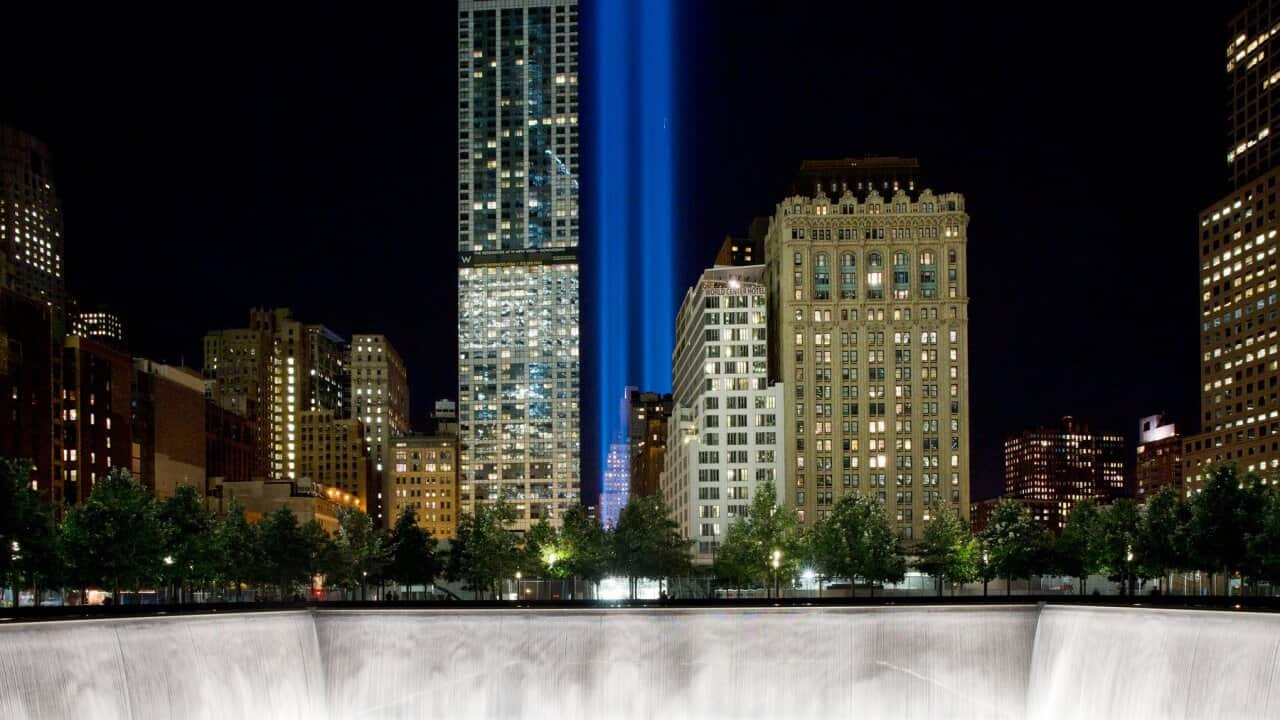 The Tribute in Light rises behind buildings adjacent to the World Trade Center