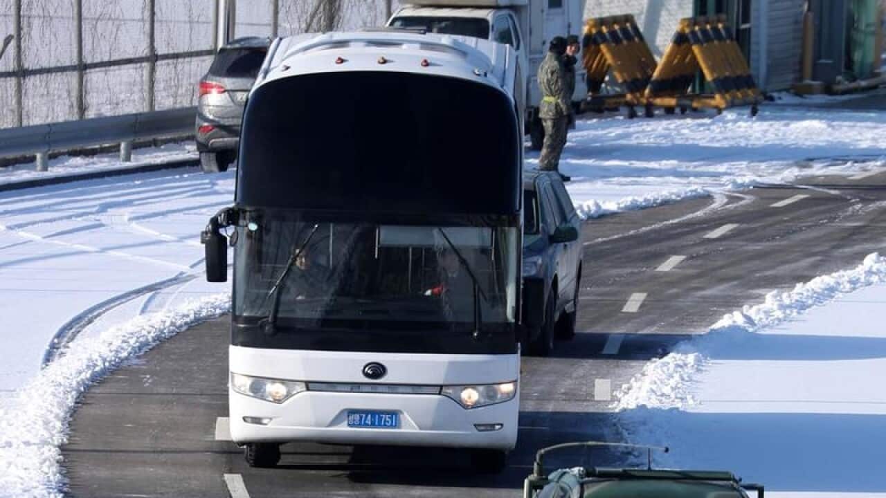 A bus carrying North Korean ice hockey players crosses a boarder.