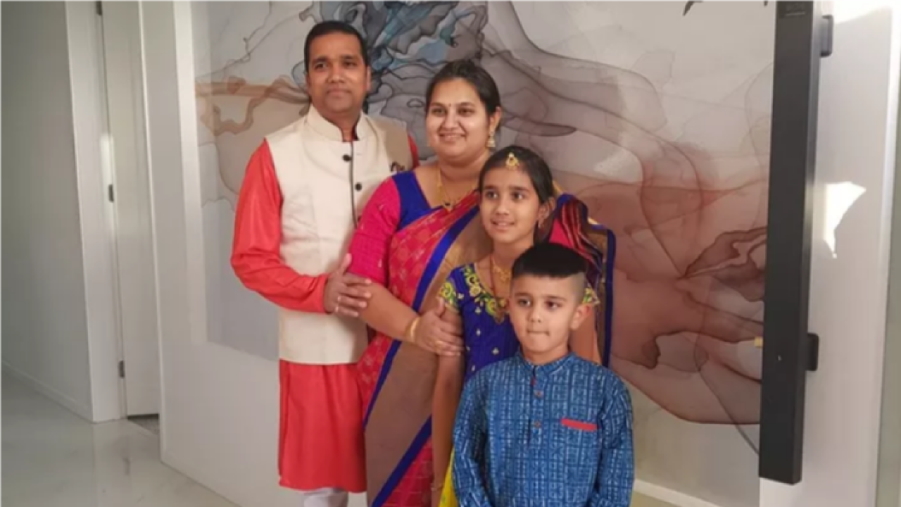 Parents, daughter and son stand together in a line, wearing traditional south Indian dress 