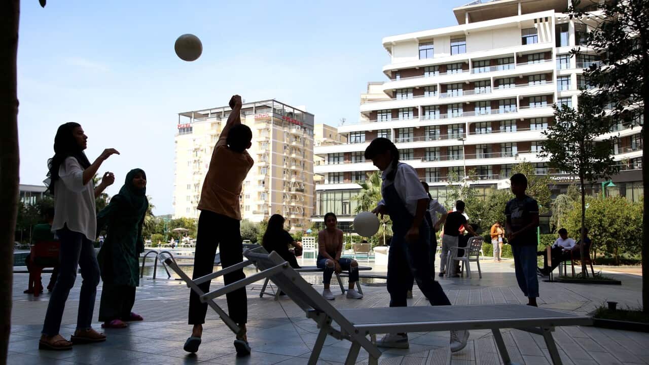 Afghan children play outside a tourist resort in the Albanian coastal city of Shengjin