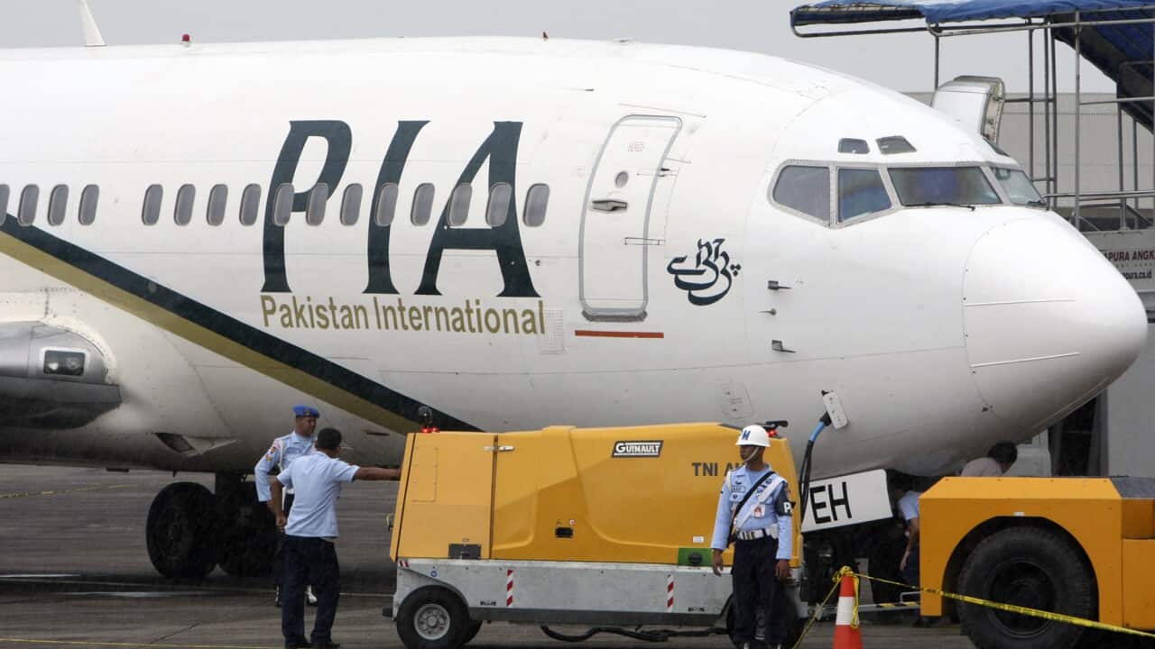 A Pakistan International Airlines passenger jet is parked on the tarmac.