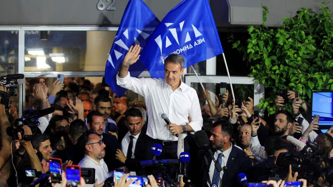 Greek Prime Minister Kyriakos Mitsotakis celebrating in a crowd of followers after his election victory.