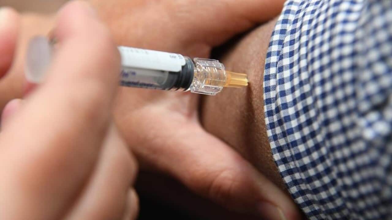 A man is seen receiving a flu immunisation