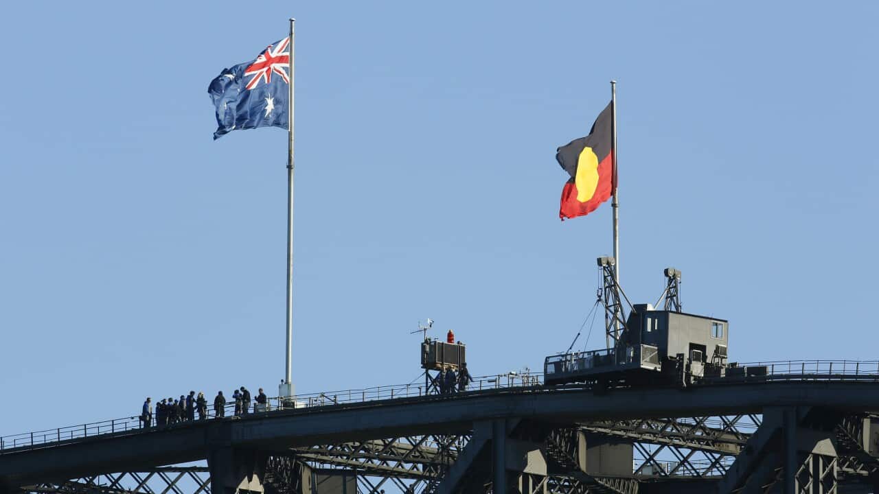 The Australian flag flies alongside the Aboriginal flag on the top of the Sydney Harbour Bridge