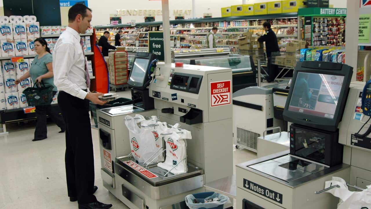 A shopper uses a self-serve supermarket checkout in a New World store in Auckland, New Zealand