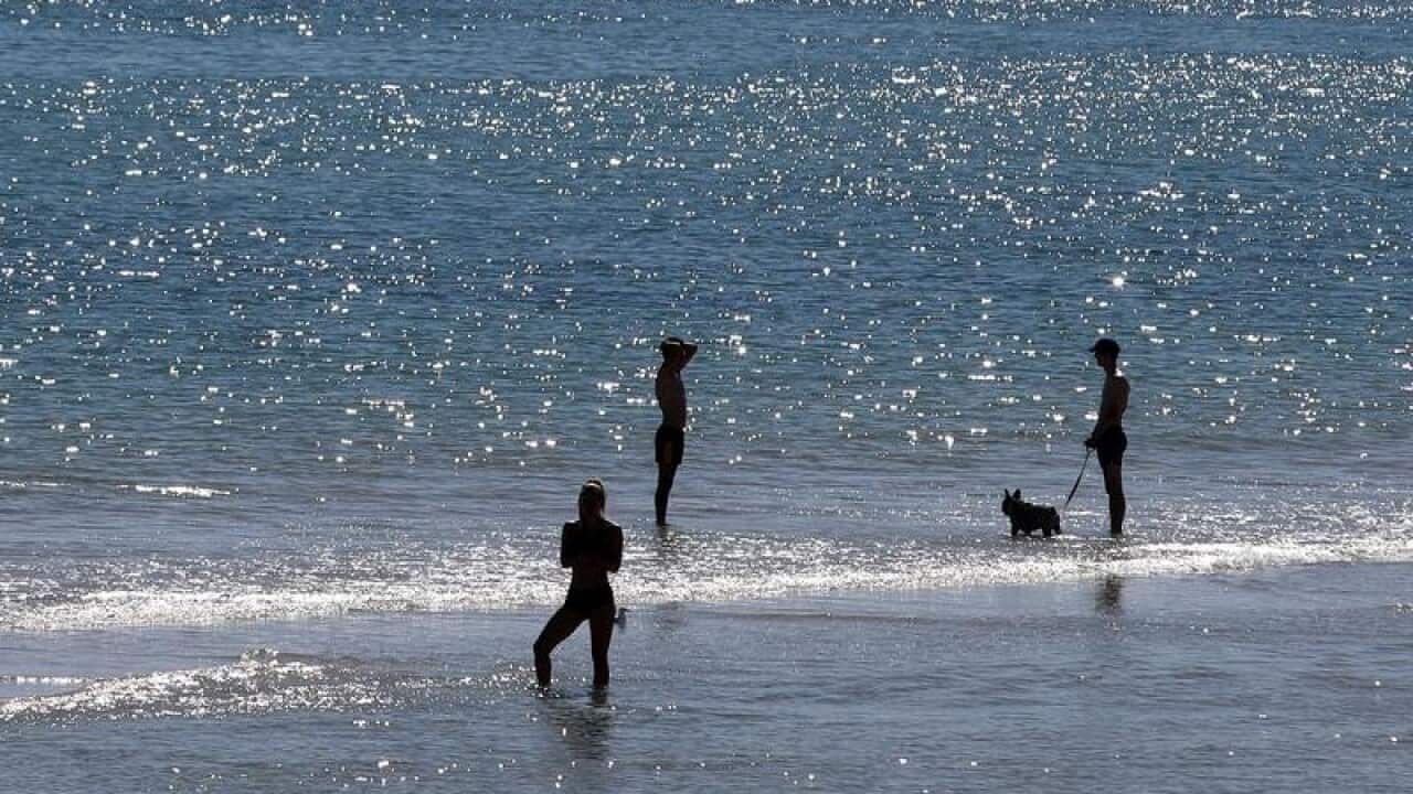 People are seen enjoying the hot weather on Henley Beach in Adelaide