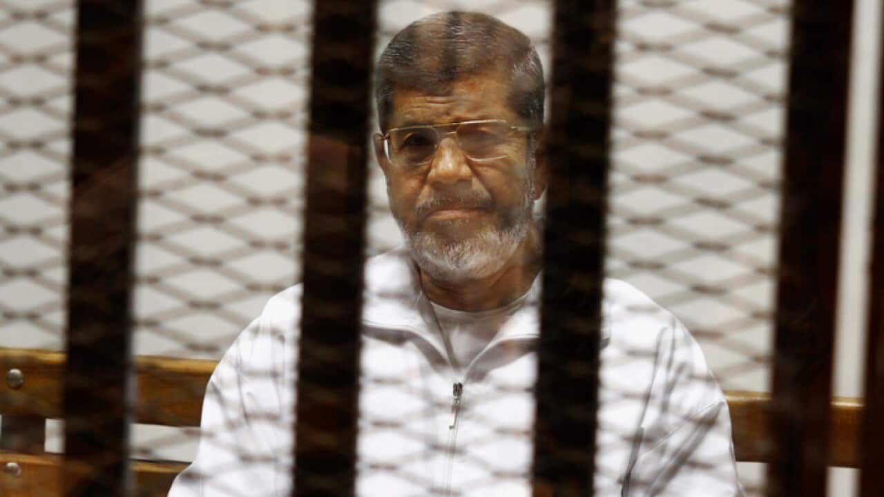 In this May 8, 2014 file photo, Egypt's ousted Islamist President Mohammed Morsi sits in a defendant cage in the Police Academy courthouse in Cairo, Egypt.