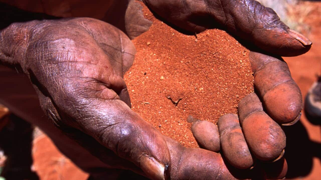 Red sand in the hands of an aboriginal person.