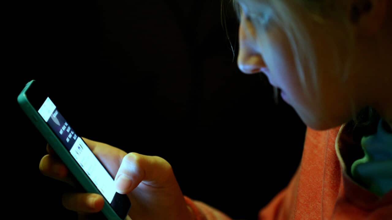 A teenage girl uses an iPhone