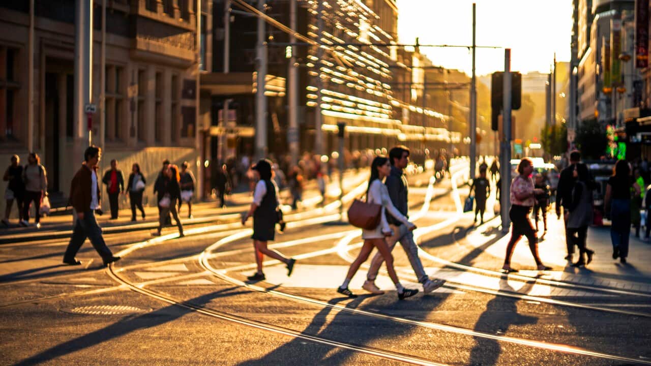 Pedestrians crossing city street at dusk
