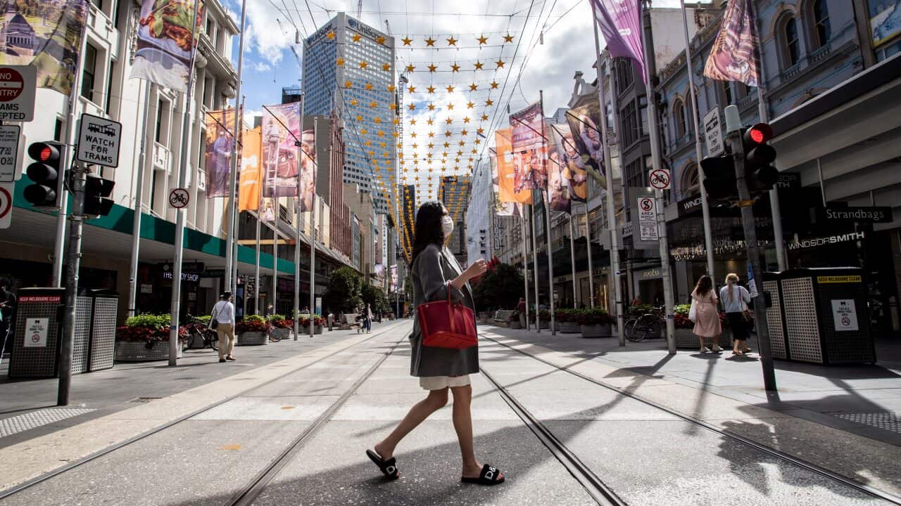 A woman wearing a face mask seen crossing the Bourke Street Mall in Melbourne.