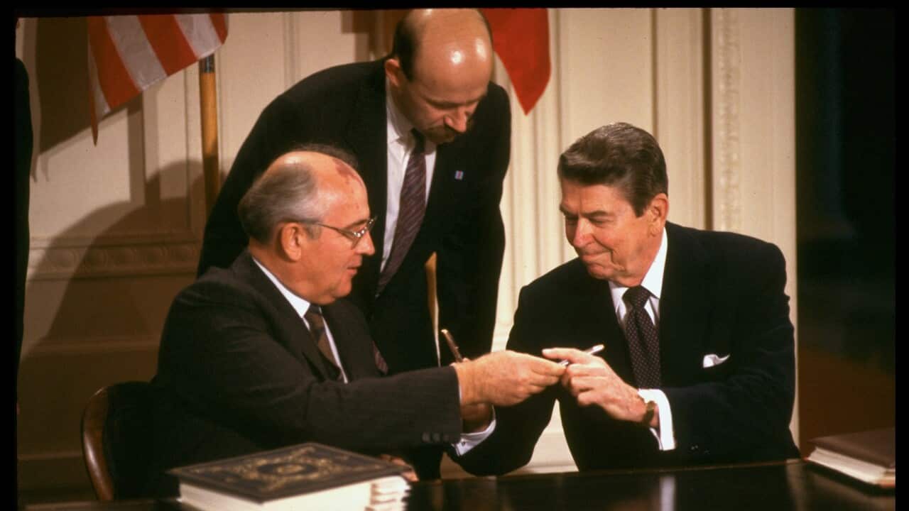 Reagan And Gorbachev exchanging pens during INF agreement signing.