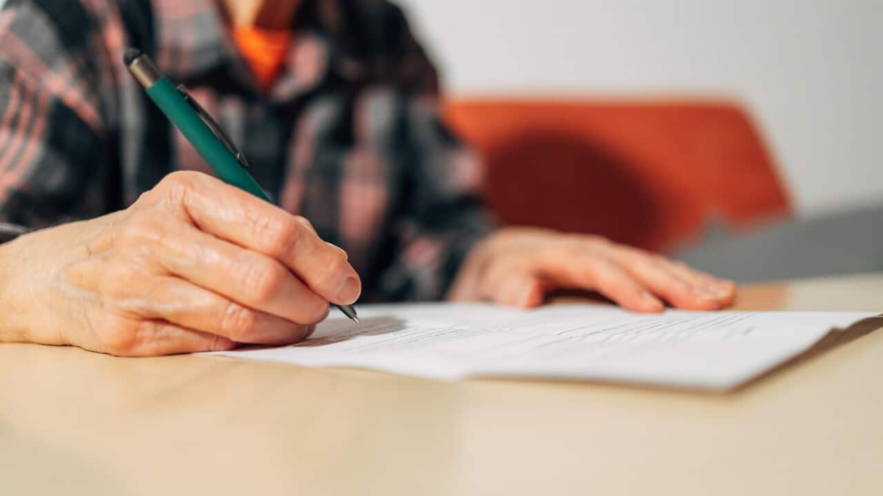 Senior adult woman signing important legal document