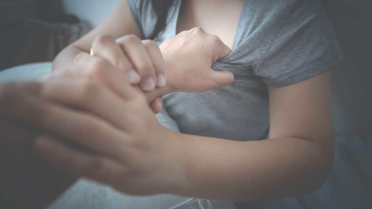 Cropped Hand Of Man Harassing Woman Sitting On Bed At Home
