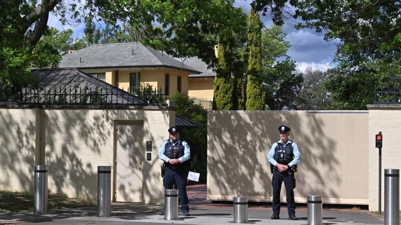 Two uniformed policemen standing guard outside a property