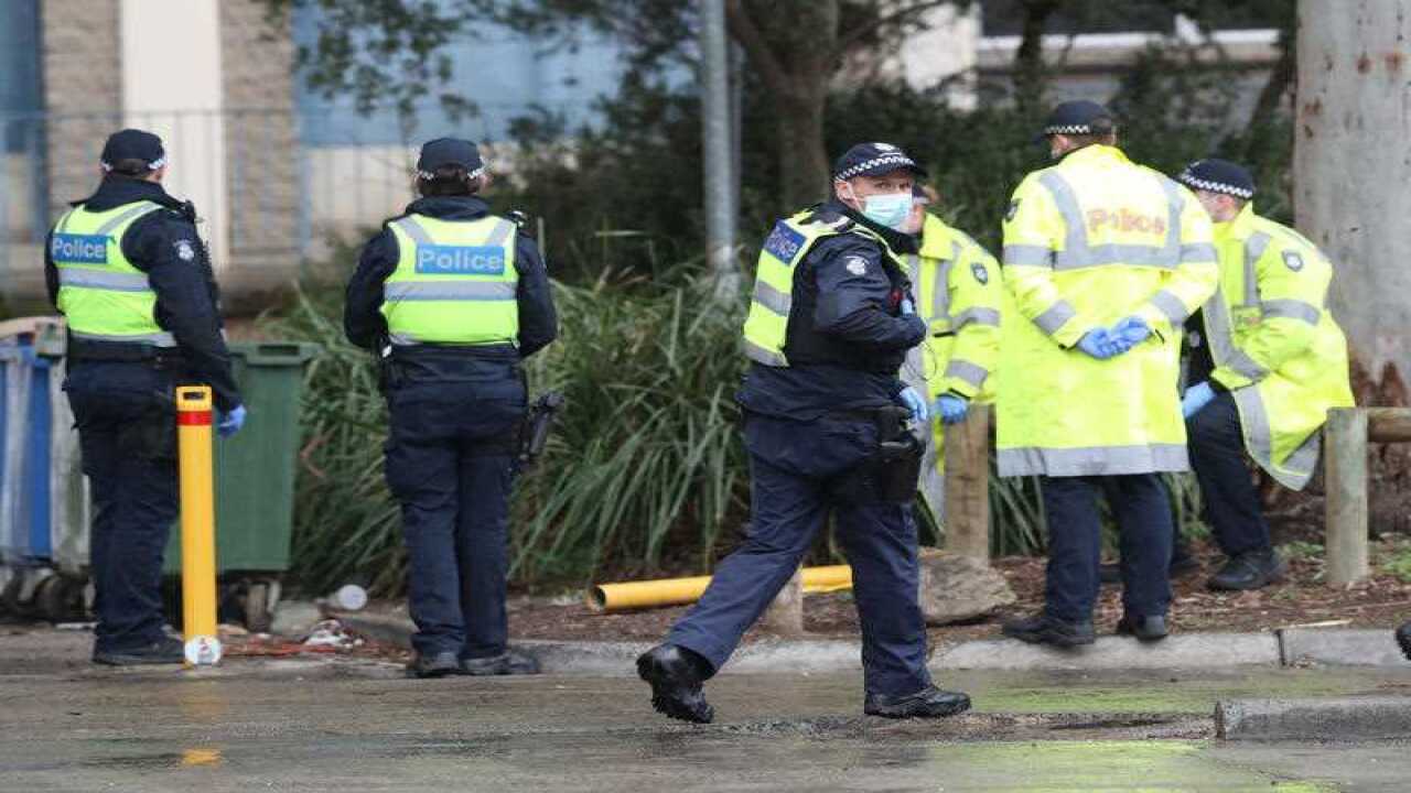 Police are seen outside the Alfred Street public housing tower which remains under tight lockdown in North Melbourne, Saturday, July 11, 2020