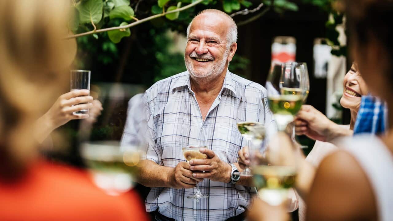 Elderly Man Making Toast At Family BBQ.