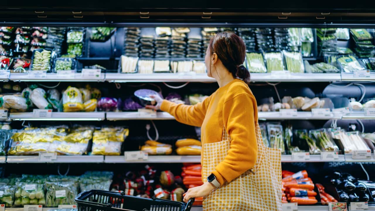 Young Asian woman with shopping cart, carrying a reusable shopping bag, shopping for fresh organic fruits and vegetables in supermarket. Environmentally friendly concept. Zero waste and plastic free. Eco friendly shopping. Sustainable living lifestyle