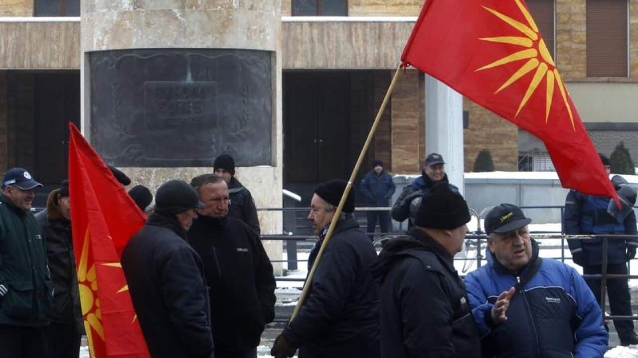 People attend a protest against the change of Macedonia's name outside the country's parliament.