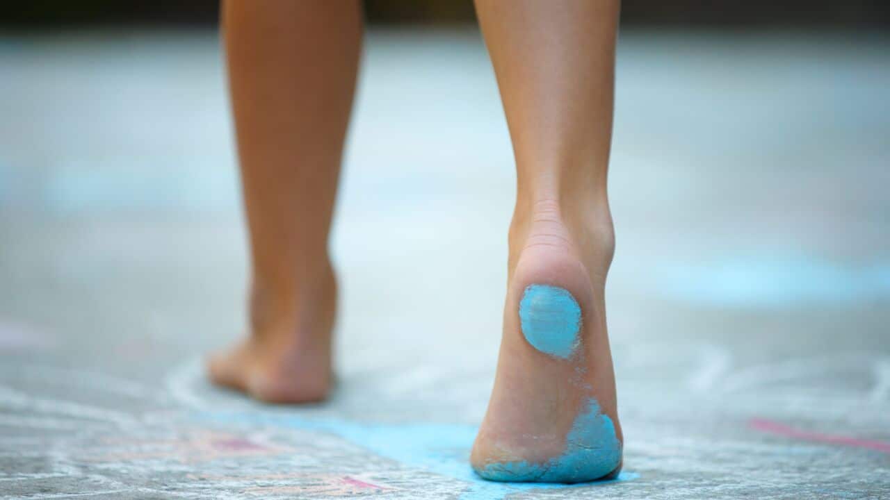 Rear shot of the sole of a boy's foot covered in blue chalk