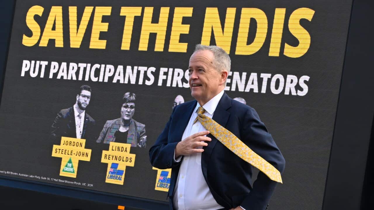 Bill Shorten poses for photographs next to a truck with a billboard saying ‘Save the NDIS’ (AAP)