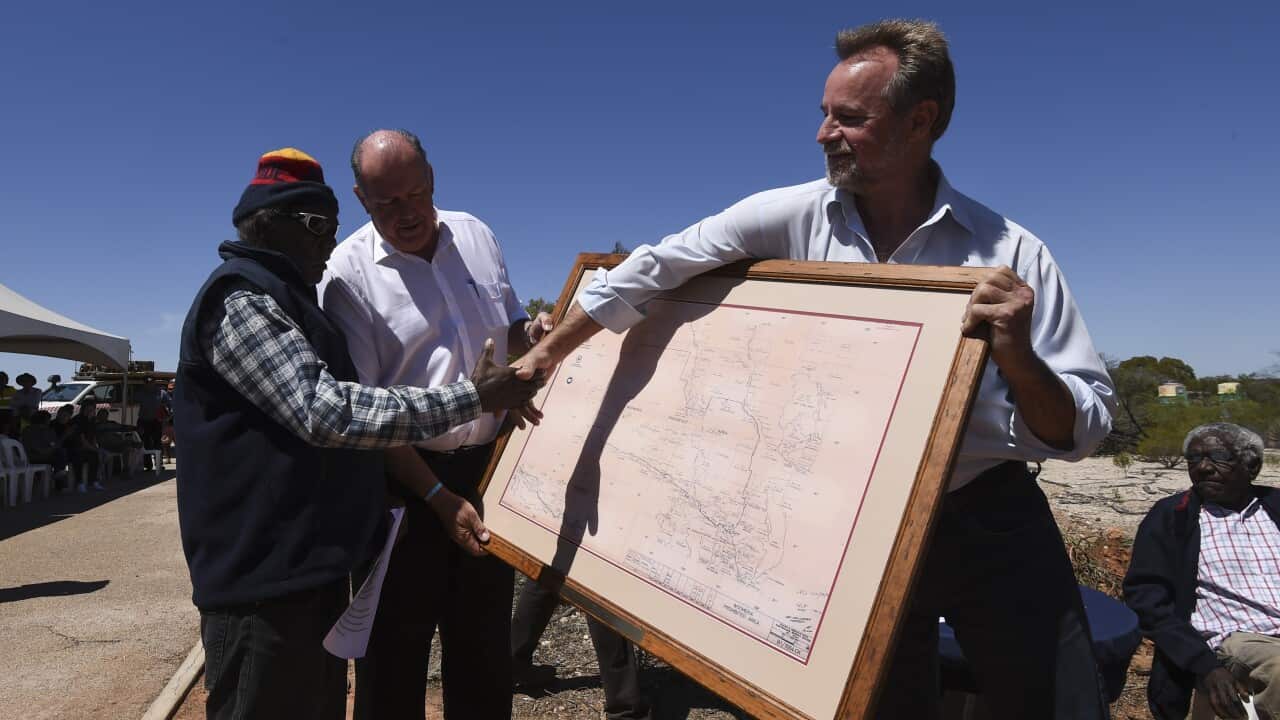 Defence Minister David Johnston and Minister for Indigenous Affairs Nigel Scullion hand over a map to Maralinga-Tjarutja council chair Keith Peters during a ceremony for the excision of Section 400 from the Woomera Prohibited Area in Maralinga, SA, Nov. 5