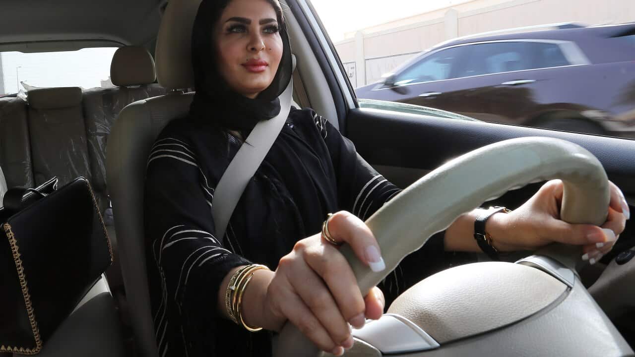 Huda al-Badri, 30, poses behind a steering wheel of a car in the early morning hours when the royal decree lifted ban on women driving a car in Saudi Arabia.